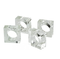 The Tizo Crystal Cube Napkin Ring Set of 4 – Clear features four transparent, square-shaped acrylic napkin rings arranged together on a white background. Each ring has a circular center opening to hold a napkin, making them a stylish addition to any table setting.