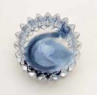 The Splash Catchall Bowl by Gary Bodker is a small, round handcrafted glass dish with jagged edges and swirling light and dark blue accents—an ideal artisan home décor piece.