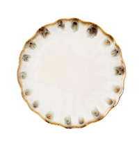 The Amoria Dinnerware by Blue Pheasant features a round ceramic plate with a wavy, scalloped edge and brownish accents along the rim, offering vintage-inspired elegance perfect for any table setting.