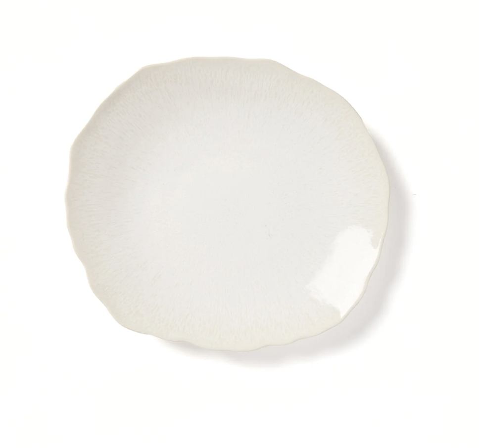 A round, off-white ceramic plate from the Plume White Dinnerware Pearl collection by Jars - Rosenthal, featuring a subtle textured pattern and a gently wavy edge, photographed on a white background.