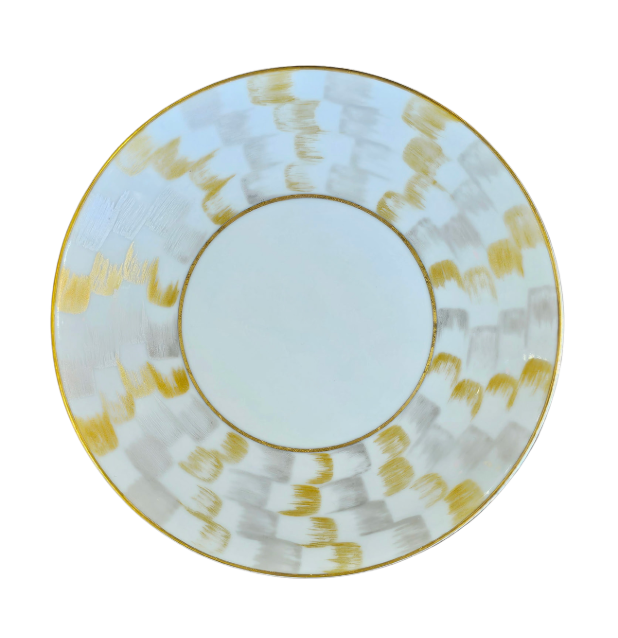 The Marie Daâge Zephyr 1 Dinnerware by Marie Daâge is a round white porcelain plate with a wide rim adorned with a hand-painted gold and silver checkered pattern, photographed on a white background.