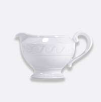 The Bernardaud Louvre Dinnerware gravy boat, crafted from white ceramic with a curved handle and embossed swirl pattern inspired by Renaissance elegance, is set against a plain light background—an ideal accent for your white service.