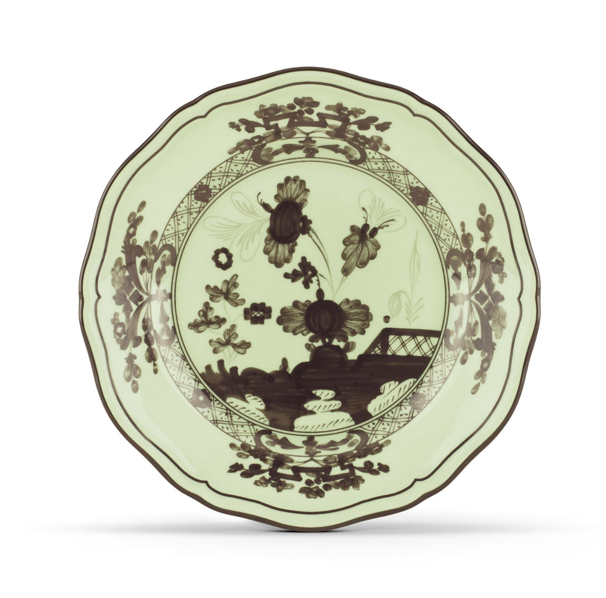 A decorative ceramic plate from the Ginori 1735 Oriente Italiano Dinnerware Bario collection, showcasing a pale green background with dark floral and landscape motifs and a scalloped edge, inspired by classic chinoiserie design.