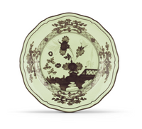 A decorative ceramic plate from Ginori 1735’s Oriente Italiano Dinnerware Bario collection, featuring a scalloped edge, a pale green background with dark brown floral patterns, and a bridge design in the center, inspired by classic chinoiserie.