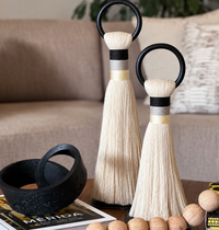 The Musas Thick Hoop Object - Shadow - Medium by CDMX / AWANA, paired with books and a black bowl, adds modern charm to a wooden table in this cozy, art-inspired living room.