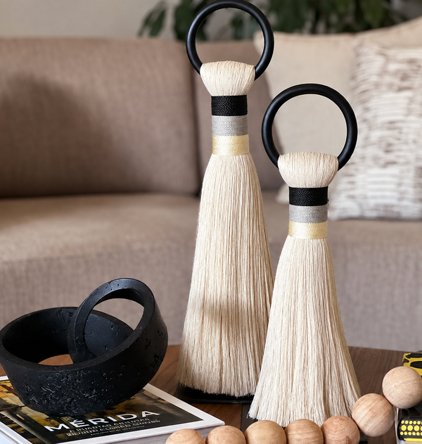 The Musas Thick Hoop Object - Shadow - Medium by CDMX / AWANA, paired with books and a black bowl, adds modern charm to a wooden table in this cozy, art-inspired living room.