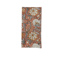 Block Print Napkin Set of 4 - Rust: a rectangular cotton napkin with a rust-colored background and a white and grey floral block print pattern.