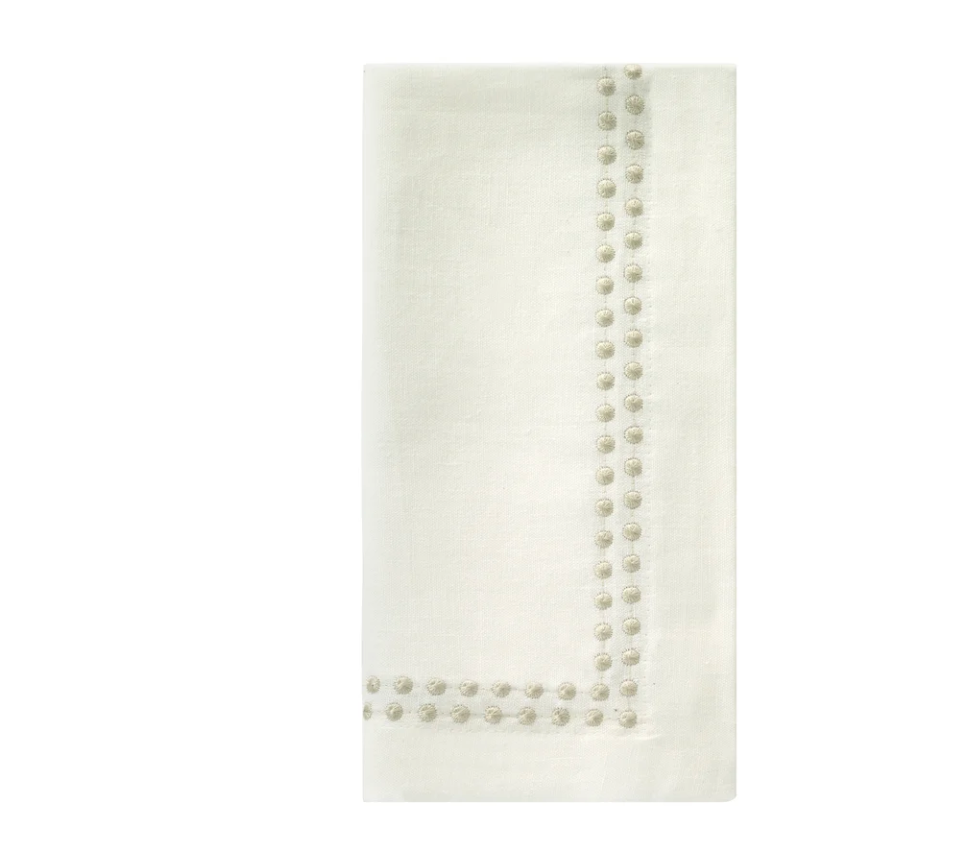 Beige Pearls Napkin Set of 4 with a border of embroidered circular details along two adjacent edges.