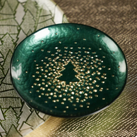 A small, dark green Glistening Tree Plate featuring a central gold tree surrounded by gold speckles.