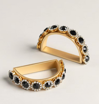 Amaryllis Golden Bar Napkin Ring Set of 4 featuring gold-toned semi-circular rings handcrafted with black stones surrounded by small clear crystals.