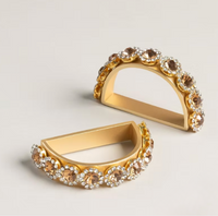 A set of four semicircular Golden Bar Napkin Ring napkin rings decorated with rows of amber-colored and clear rhinestones, serving as elegant handcrafted table jewelry.