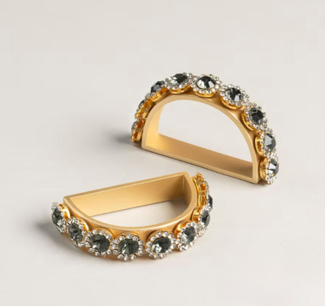 A set of four elegant, semi-circular Golden Bar Napkin Ring set of 4, featuring dark circular stones surrounded by smaller clear crystals.
