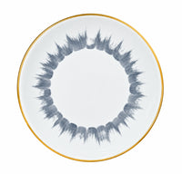Marie Daâge Iris 1 dinner plate in white Limoges porcelain with a gold rim and a circular, grey, hand-painted brushstroke pattern.