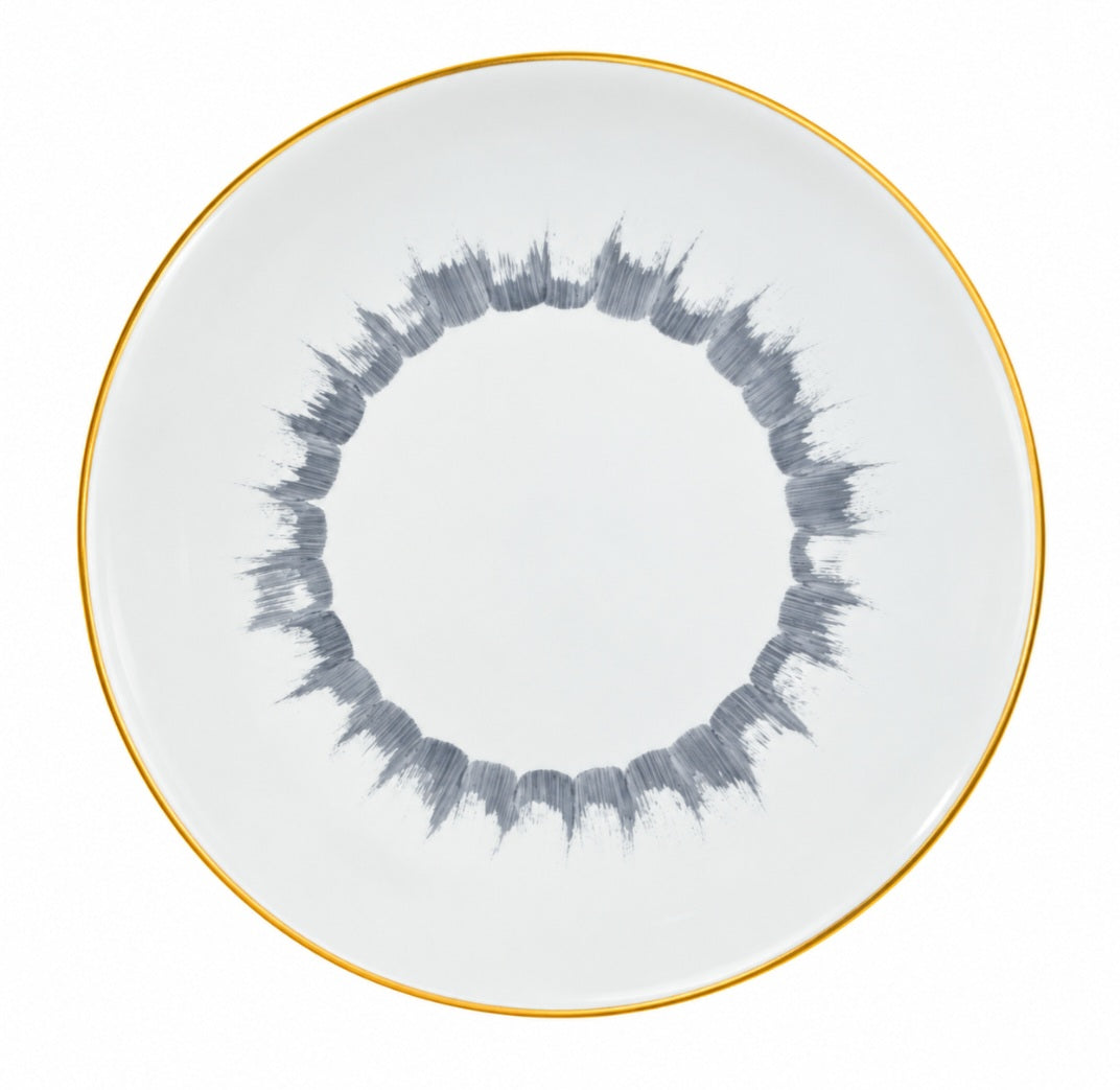 Marie Daâge Iris 1 dinner plate with a thin gold rim and a circular pattern of grey brushstrokes in the center.