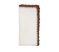 The Shell Edge Napkin Set of 4 by Kim Seybert features neatly folded linen napkins with decorative hand-crocheted raffia borders—ideal for adding rustic elegance to your table setting.