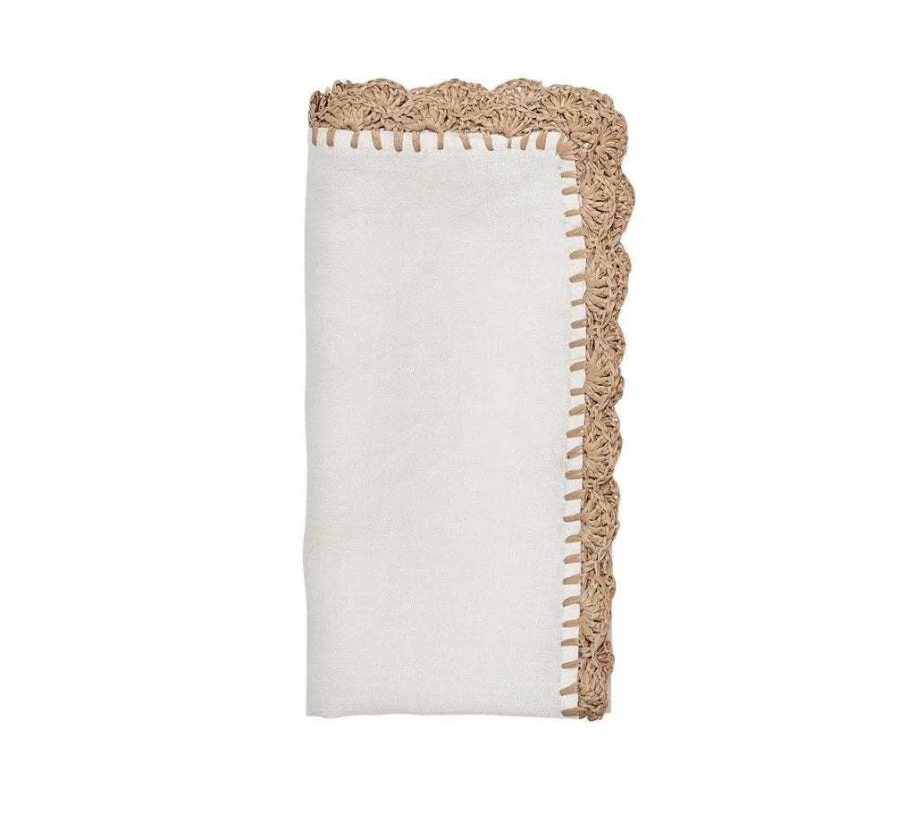 The Shell Edge Napkin Set of 4 by Kim Seybert features folded white linen napkins with tan hand-crocheted raffia lace trim and decorative stitching, shown on a plain white background.