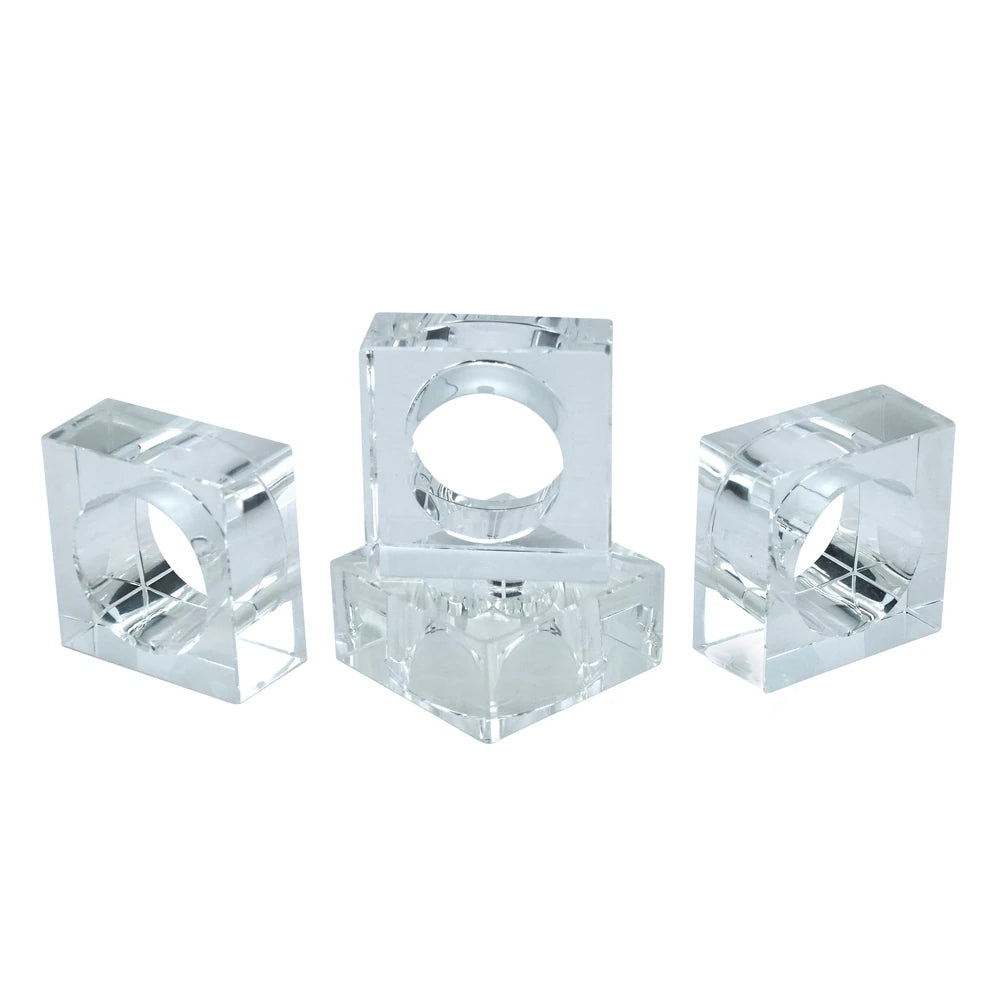 Four Crystal Cube Napkin Rings by Tizo are arranged together, highlighting a stylish set of four perfect for any table setting. Each clear napkin ring features a square block design with a circular center to hold your napkins. The display is set against a white background.