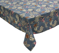A rectangular table covered with the Kim Seybert Paisley Vine Tablecloth in Blue & Gray (54x126″)—a blue and gray tablecloth featuring an intricate floral and paisley pattern in cream, brown, and pink accents.