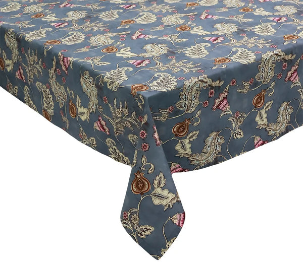 A rectangular table covered with the Kim Seybert Paisley Vine Tablecloth in Blue & Gray (54x126″)—a blue and gray tablecloth featuring an intricate floral and paisley pattern in cream, brown, and pink accents.