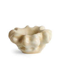 The Timna Coupe - Latte by L’Objet is a small, light beige ceramic bowl featuring an irregular, wavy, and bubbled rim for an organic, sculptural look reminiscent of a porcelain coupe. Its smooth surface boasts a slightly glossy finish.