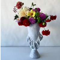 A vibrant mix of dahlias fills the "Without Her Trumpet Vase" by Ellen Robinson Studio, a hand-formed white-glazed vessel elegantly shaped as a classical bust.