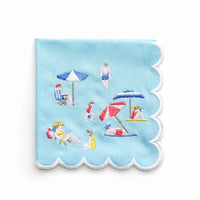 The Day At The Beach Cocktail Napkin set of 4 by Pomegranate features light blue napkins with scalloped edges and embroidered beach scenes—ideal for adding playful, coastal charm to your next gathering.