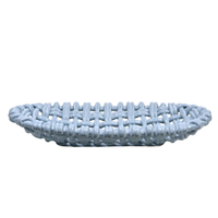 The Woven Basket Oval by Skyros is a light blue ceramic piece with an open, woven design, handcrafted by artisans in Condeixa, Portugal. Shown from the side against a plain white background.