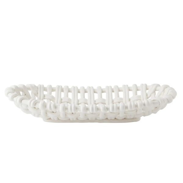 The Skyros Woven Basket Oval is a white, handwoven basket with a lattice design, crafted by artisans in Condeixa, Portugal. It has an oval shape and is pictured from the side against a plain white background.