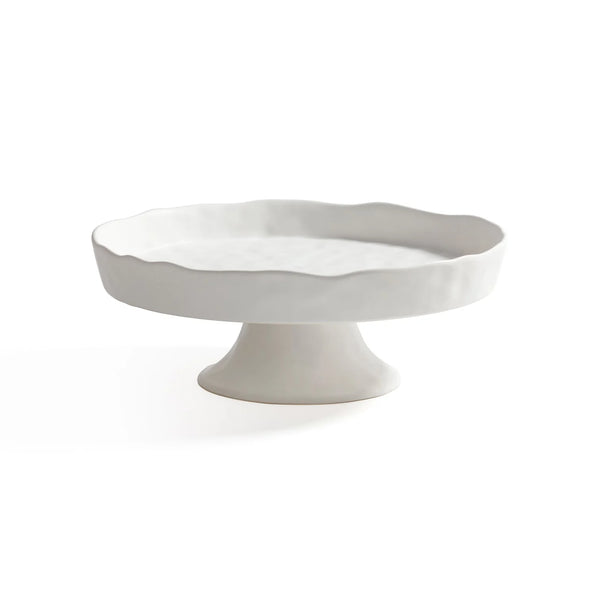 The Zodax Alto Ceramic Pedestal Bowl features a white scalloped edge and sturdy base, doubling as an elegant cake stand or footed serving bowl, shown on a plain white background.