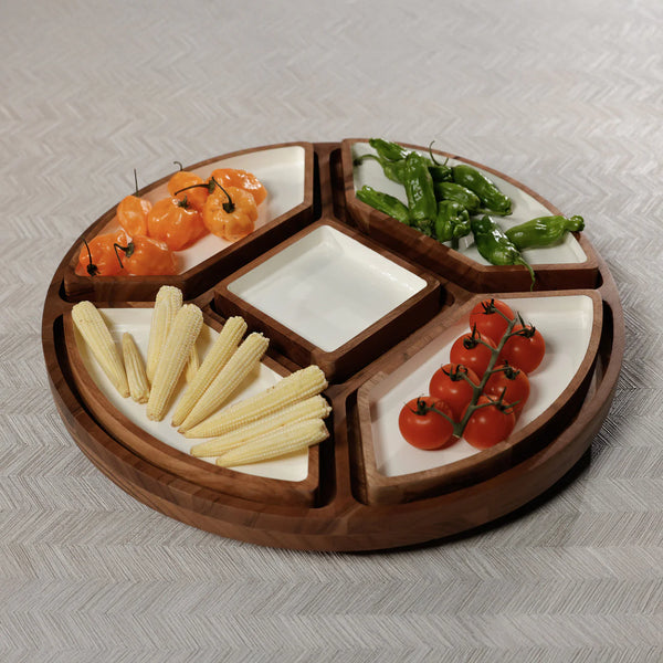 The Zodax Walden 5 Section Lazy Susan, a round serving tray with white ceramic compartments, organizes yellow baby corn, cherry tomatoes, orange peppers, and green peppers on a light patterned surface.