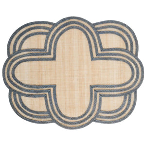 The Juliska Scallop Stripe Placemat features a beige center with an intricate blue border in an overlapping, scalloped quatrefoil pattern for a symmetrical, decorative look.
