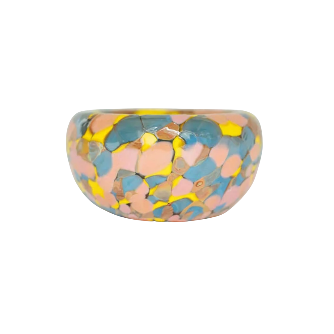 The Jelly Baby Bubble Bowl by Maria Ida Designs features a glossy, chunky dome shape adorned with a vibrant mosaic pattern in pink, blue, and yellow hues—evoking the lively aesthetic of art glass pieces—and is beautifully displayed against a white background.