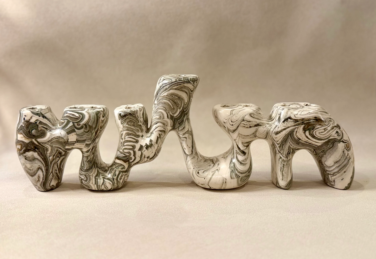 Sela Form Forma Menorah - Marble, a sculptural, wavy marble menorah with a black and white swirled pattern and nine candle holders, showcasing modern design and contemporary elegance.