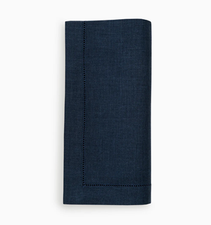 A set of four navy blue Festival Napkins by Sferra, crafted from European linen with elegant white stitching.