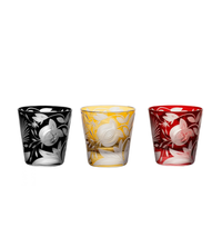 Three handcrafted Verdure Vodka / Liqueur -Bright Colors - shot glasses in black, yellow, and red, each etched with a repeating floral and pomegranate pattern.