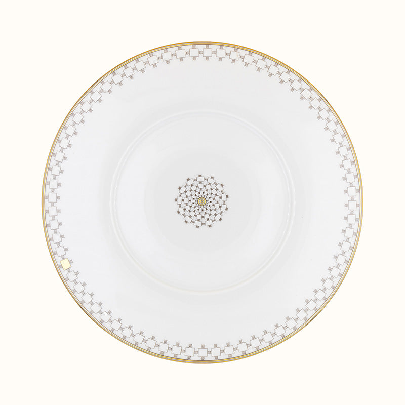 The Mottahedeh/Robert Haviland Home Dinnerware- Gold plate is round and white with a gold geometric rim and matching center motif, shown from above on a plain background.