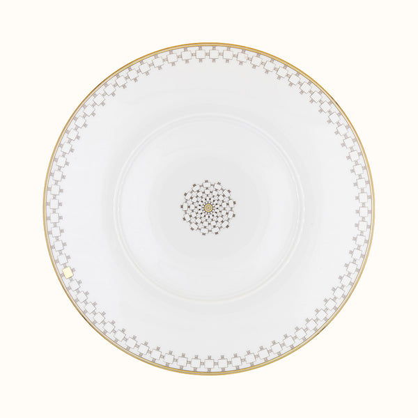 The Mottahedeh/Robert Haviland Home Dinnerware- Gold plate is round and white with a gold geometric rim and matching center motif, shown from above on a plain background.