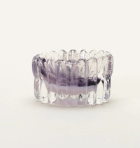 The Splash Catchall Bowl by Gary Bodker is a small, round, clear handcrafted glass dish with vertical textured ridges and a hint of purple at the base, shown on a plain white background.