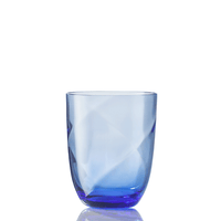 The Idra Tumbler Lente by Nason Moretti is a transparent blue glass with a slightly curved shape, displayed on a white background with a subtle reflection beneath it.
