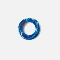 Blue ring with white marbled pattern on a light gray background