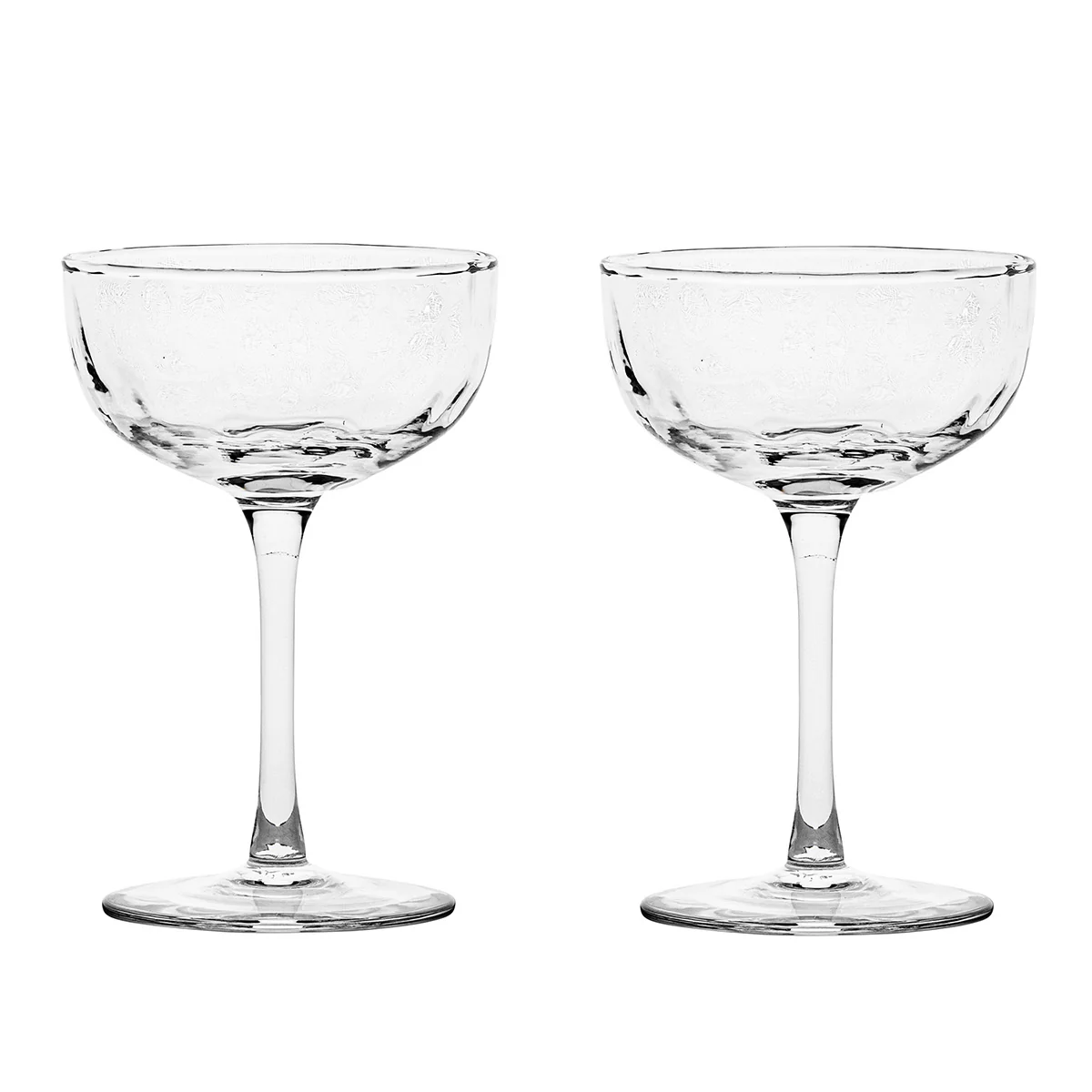 Two clear, empty Puro Cocktail Coupe glasses by Juliska, each featuring a short stem and wide, shallow bowl, are placed side by side on a plain white background—an ideal choice for serving elegant cocktails or gifting as a beautifully boxed set.