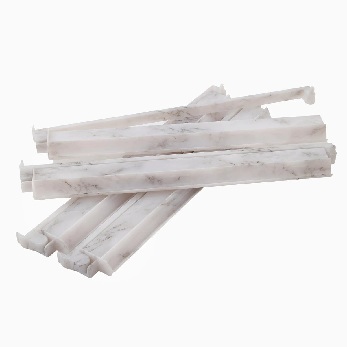 Five white, marble-patterned plastic drawer dividers are stacked on top of each other against a plain white background, evoking the sophisticated style of the Oh My Mahjong Mahjong Rack & Pusher Set - Carrara.