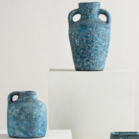 The Cavern Vase - Ocean displayed on a pedestal with two other vases. 