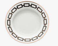 The Ginori 1735 Catene Nero Dinnerware features a white ceramic plate adorned with a black geometric chain-link pattern around the rim and finished with a thin gold edge.