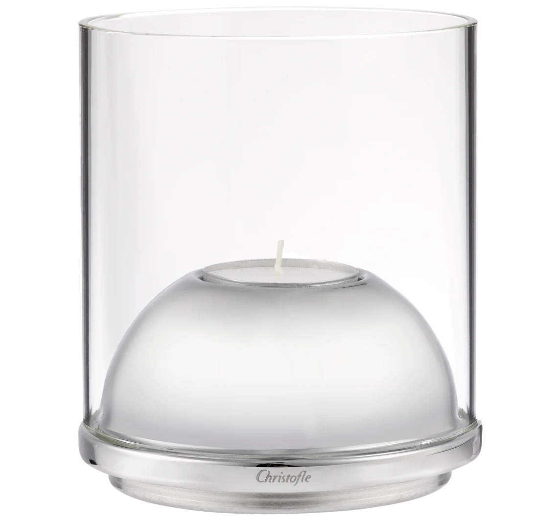 The Oh de Christofle Stainless Steel & Glass Hurricane - Small is a clear cylindrical candle holder with a silver base, dome-shaped insert, and engraved Christofle branding, holding a single small white tealight.