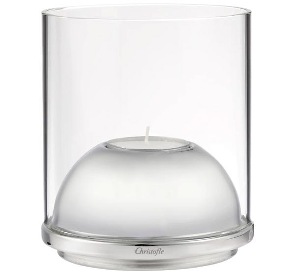 The Oh de Christofle Stainless Steel & Glass Hurricane - Small is a clear cylindrical candle holder with a silver base, dome-shaped insert, and engraved Christofle branding, holding a single small white tealight.