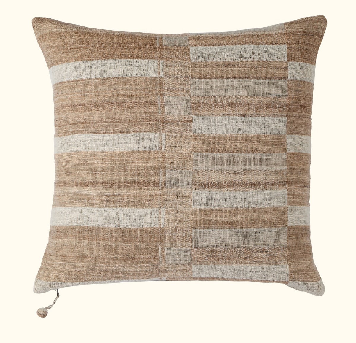 The Threads Soft Goods Sandstone Pillow 22 x 22 features a hand-woven, striped design in beige, cream, and light brown with unique charm and a tassel accent on one corner.
