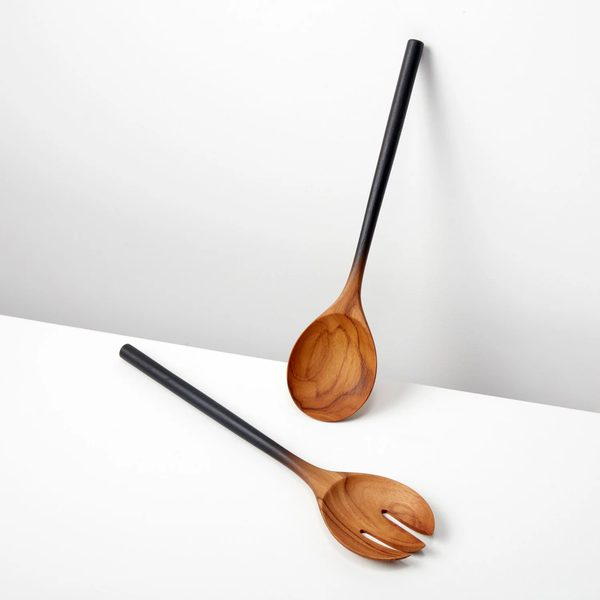 The Be Home Ombre Wood Serving Set includes two hand-crafted wooden salad utensils—a spoon and fork with dark handles—displayed on a white surface against a white background.