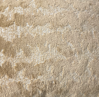 Close-up of the Decor Fifty-Five Coolney Pillow Sand, featuring a beige textured surface with small loops and raised areas for a soft, subtly uneven look.