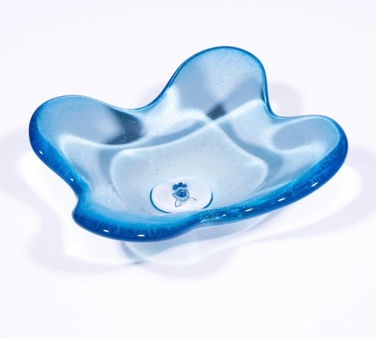 The Cloud Dish by Tyler Barry Design is a hand-blown glass bowl in translucent blue with wavy, uneven edges and a smooth, glossy finish, shown elegantly on a white background.